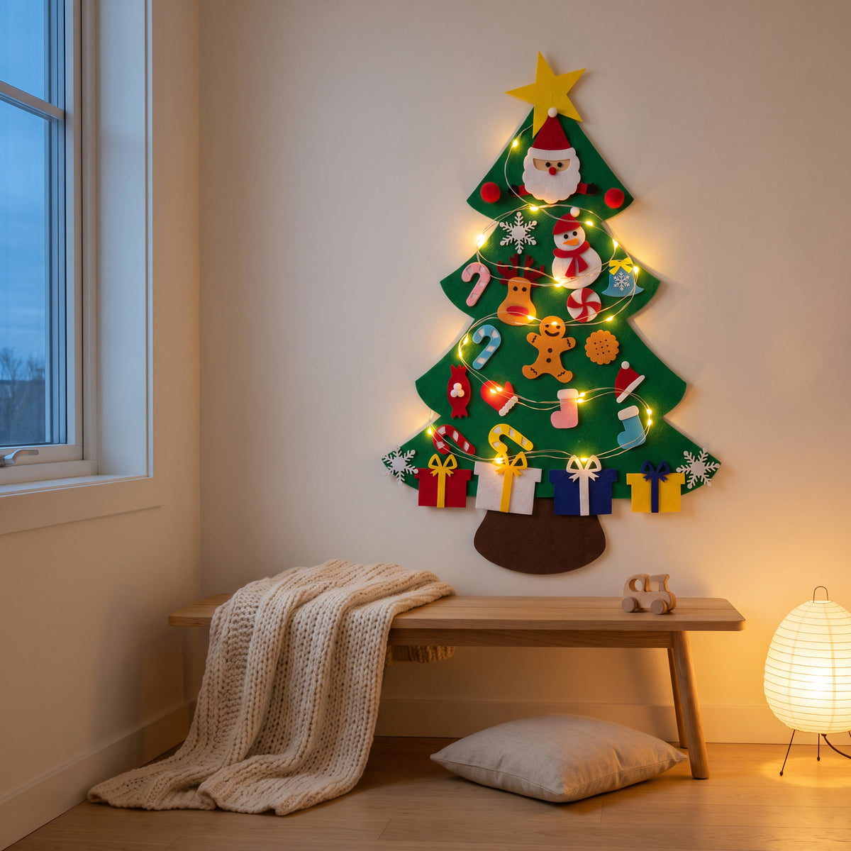 Felt Christmas tree glowing with fairy lights in a cozy bedroom at dusk